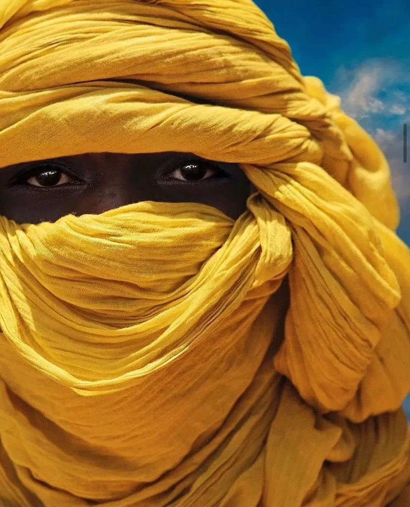 Niger: tuareg people in traditional clothes sitting on camels
