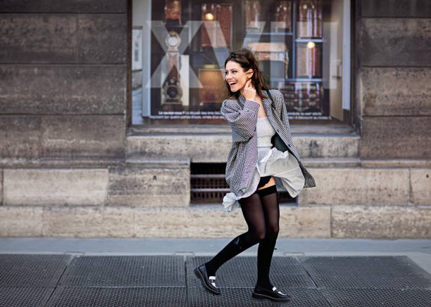 Portrait of woman walking on the street and wind blowing her skirt