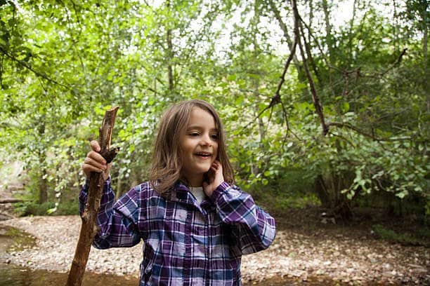 cute little girl in a wicking shirt having fun by the river